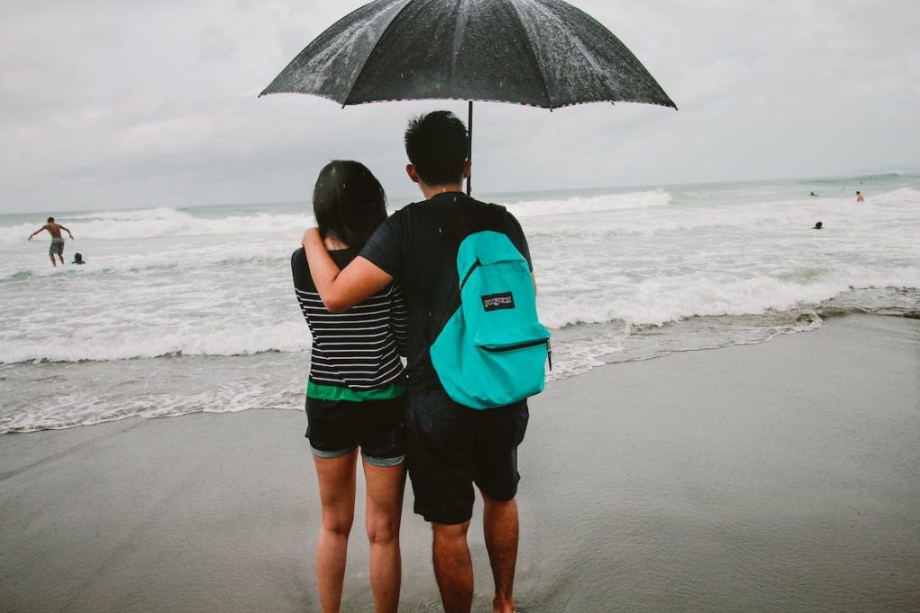 a man with swim backpack holding an umbrella