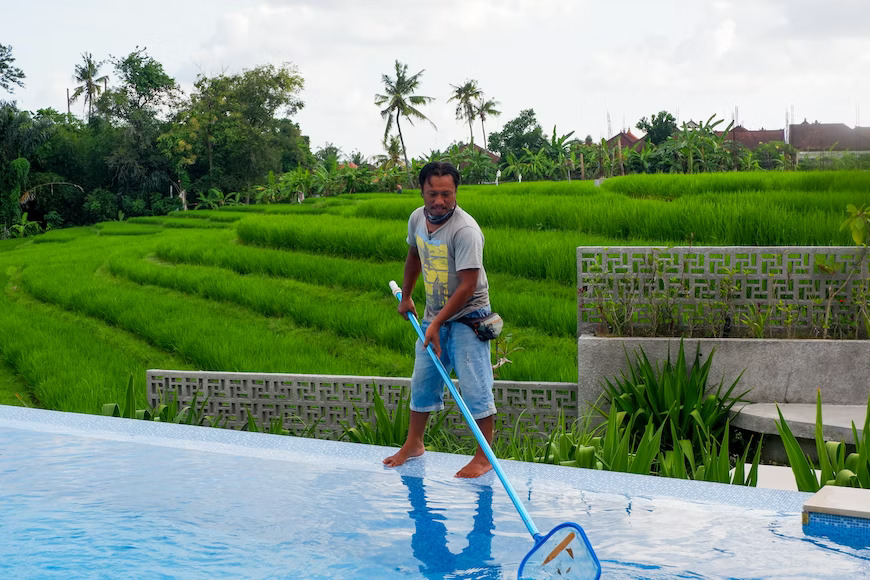 male swimmer cleaning a swimming pool