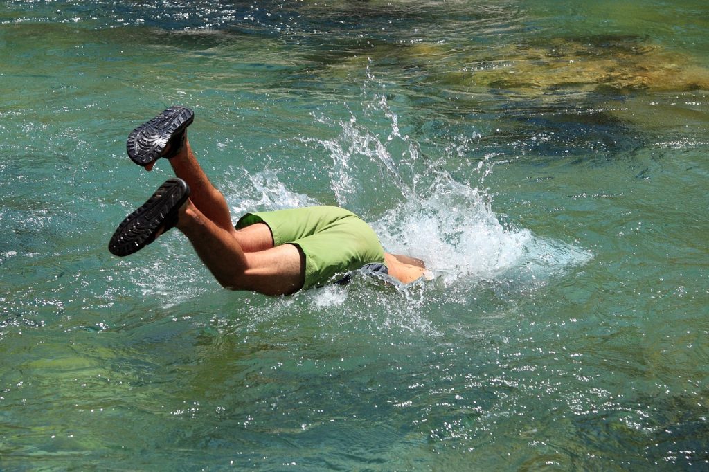 young male swimmer diving in the pool