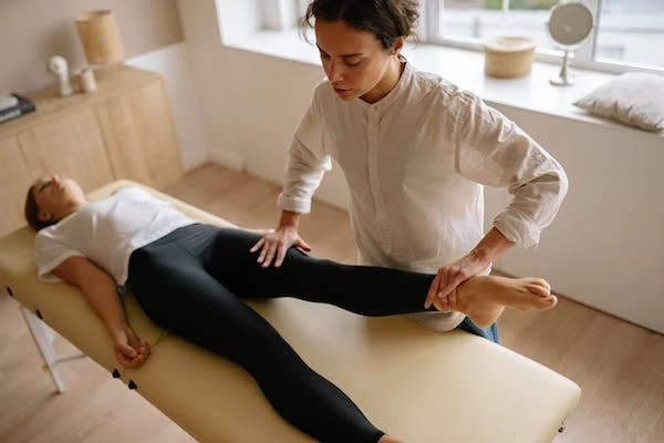 Physiotherapist massaging a lady Leg after swimming