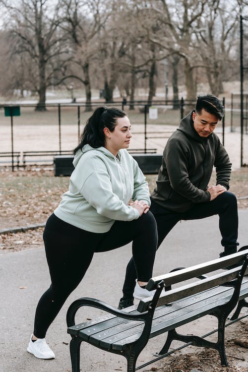 Young female with male instructor exercising together