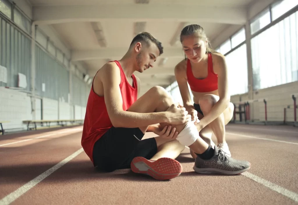 lady wrapping bandage on a man leg to relieve muscle cramps