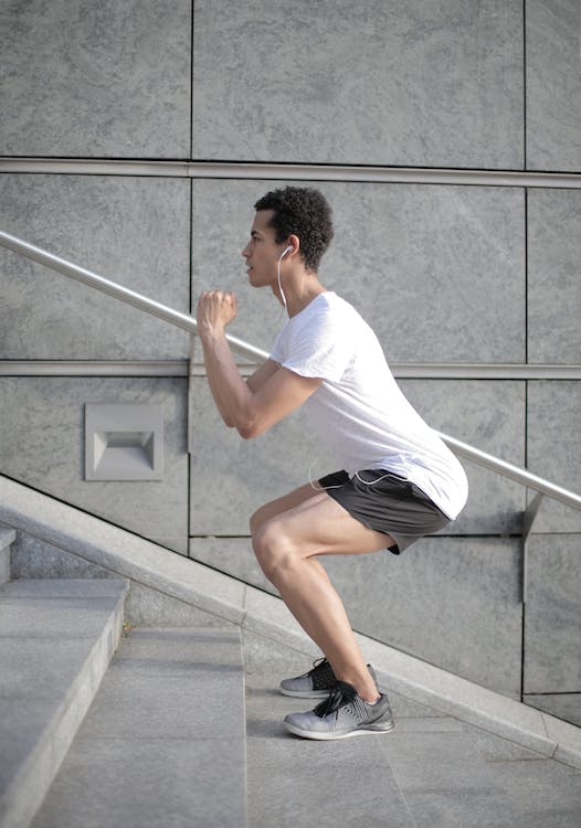 Young focused sportsman exercising on stairs