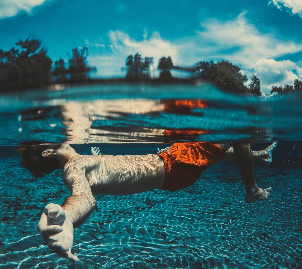 male swimmer swimming under the water to the open turn