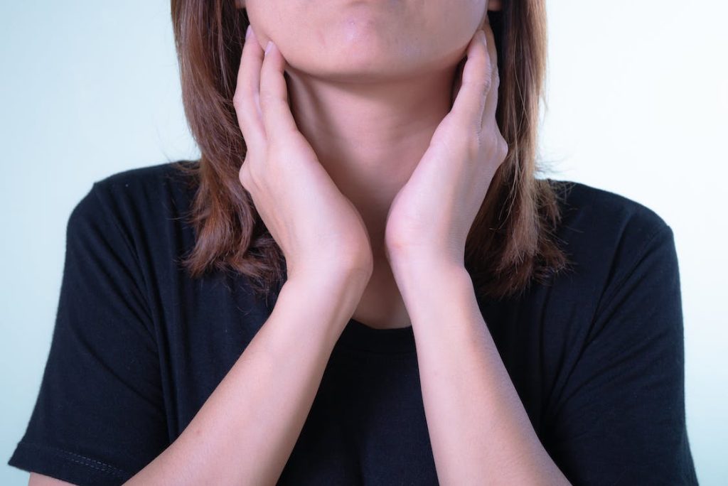 a female touching her neck after experiencing swimming neck pain