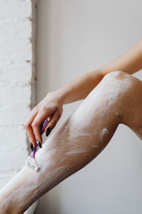 a female hairy swimmer shaving her leg