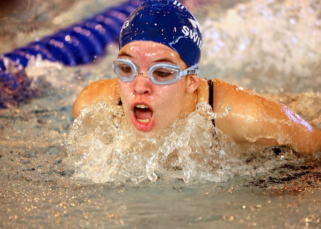 female swimmer swimming with a blue swim cap
